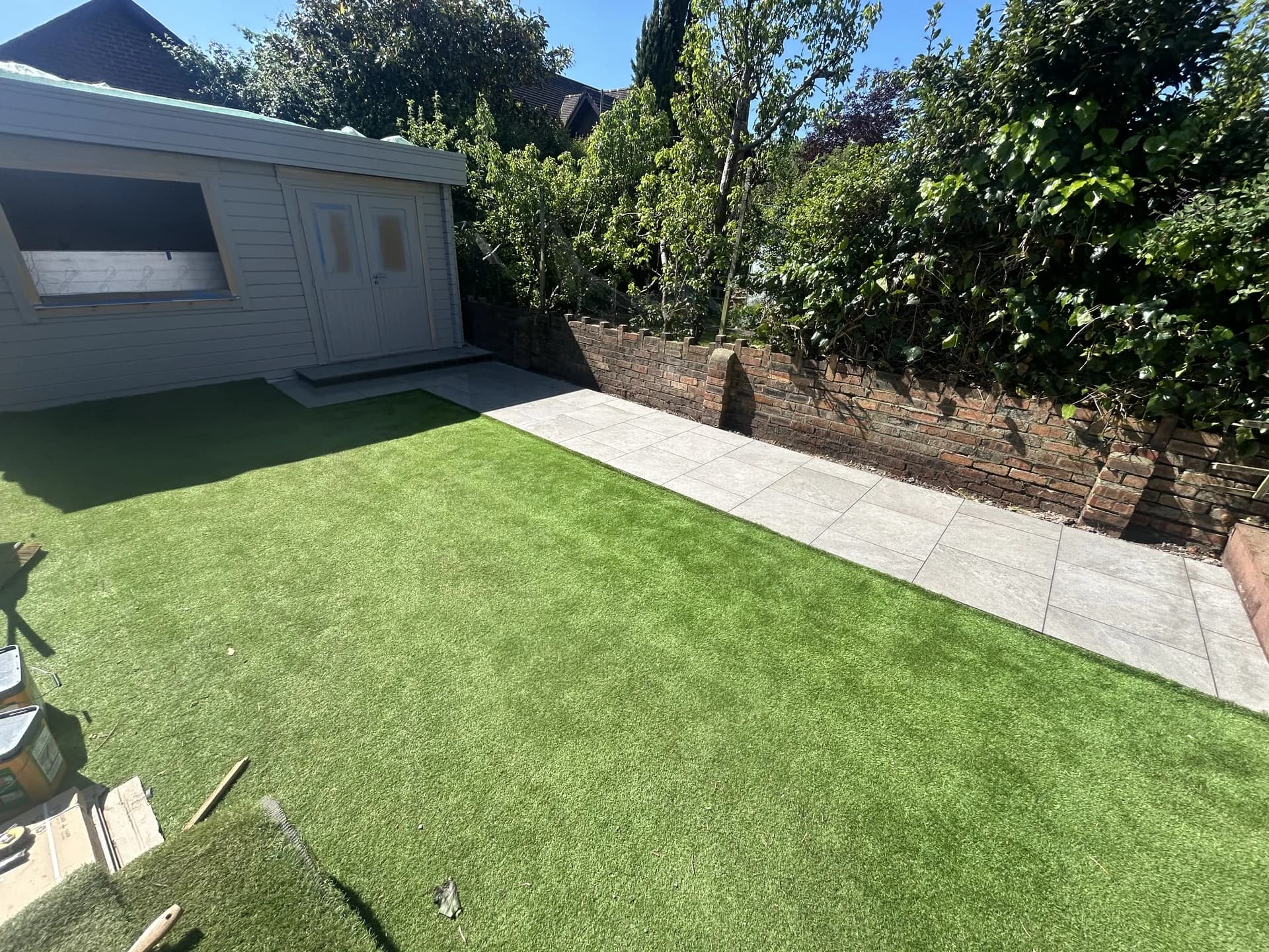 Garden landscaping with artificial grass and summer house by Reynolds Brickwork in Cardiff